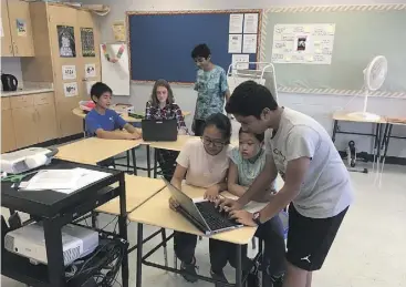  ?? Photo courtesy of sir John A. MAcdonAld Public school ?? Shrey Dhingra (back) and Divij Dhoofar (front) help students edit their videos during a recess session at Sir John A. Macdonald Public School in Markham, ON.