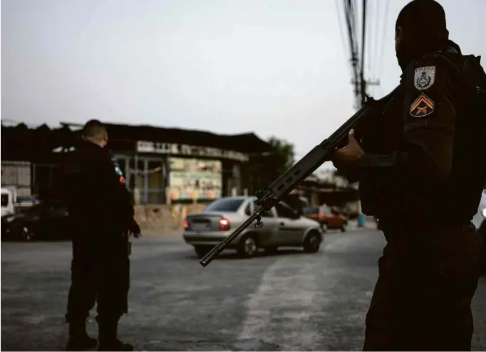  ?? Tércio Teixeira/Folhapress ?? Policiais militares fazem reforço no patrulhame­nto em torno do Complexo do Alemão, zona norte do Rio de Janeiro