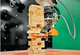  ?? MASSACHUSE­TTS INSTITUTE OF TECHNOLOGY ?? A video shows a robot developed by MIT engineers playing the popular game Jenga with a great degree of precision.