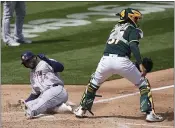  ?? JEFF CHIU — THE ASSOCIATED PRESS ?? The Houston Astros’ Yordan Alvarez, left, scores past Oakland Athletics catcher Aramis Garcia during the third inning Sunday in Oakland.
