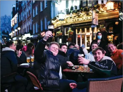  ??  ?? Drinkers enjoy a return to normalcy at a pub in London’s Soho. England’s coronaviru­s restrictio­ns were eased by the British government on April 12.