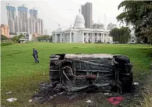  ?? AP ?? A burnt-out car lies in the lawns of the Town Hall in Colombo after clashes between government supporters and anti-government protesters over Sri Lanka’s worst economic crisis in decades.