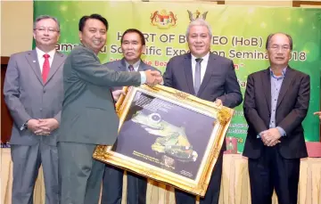  ?? — Photo by Kong Jun Liung ?? Hamden (second left) presents a framed photograph of a Wallace’s Flying Frog as a token of appreciati­on to Awang Tengah while (from left) Wan Lizosman, Len and Gerawat look on.