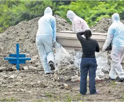  ?? Foto: EFE ?? TRABAJOS. Los médicos aplican las muestras post mortem y ayudan con el terraje de los cuerpos.