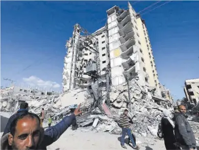  ?? Mohammed Abed / AFP ?? Un hombre señala un edificio destruido por las bombas israelís en la ciudad gazatí de Rafah.