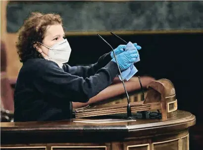  ??  ?? Una uixer netejant el micròfon del faristol del Congrés dels Diputats, una pràctica ara habitual