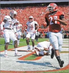  ?? Brett Davis/AP ?? Georgia running back Nick Chubb (27) runs past Nicholls defensive backs Christian Boutte (1) and Jeff Hall (10) for a touchdown in the first half of an NCAA college football game Saturday, Sept. 10, 2016, in Athens, Ga.