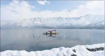  ?? WASEEM ANDRABI /AQIL KHAN/HT ?? A man rows a boat on the Dal Lake in Srinagar; and (below) people enjoy skiing in Manali on Tuesday.