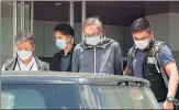  ?? AP/FILE ?? Police officers escort publisher Cheung Kim-hung (centre) at Apple Daily headquarte­rs in Hong Kong.
