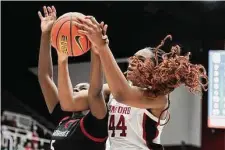  ?? Photos by Carlos Avila Gonzalez/The Chronicle ?? Above: Stanford sophomore Kiki Iriafen tussles for a rebound in the first half of the Cardinal’s blowout win at Maples Pavilion. Right: Freshman guard Indya Nivar glides for a layup, part of a 13-point, four-rebound performanc­e.