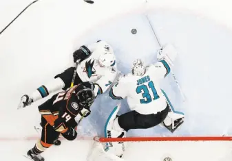  ?? Chris Carlson / Associated Press ?? With teammate Paul Martin on the ice, Sharks goaltender Martin Jones blocks a shot by Anaheim center Adam Henrique during the first period of Game 2 of the first-round series.