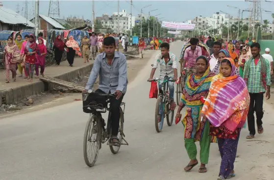  ??  ?? Textilarbe­tare på väg till jobbet utanför Dhaka.