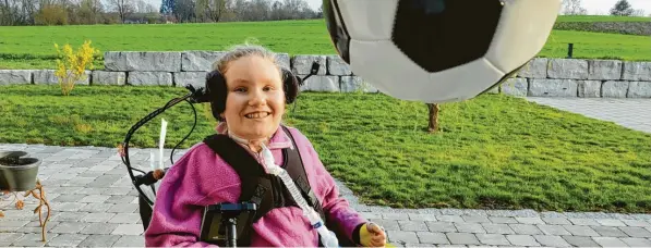  ?? Foto: Barbara Würmseher ?? Emily spielt mit einem Fußball auf der Terrasse ihres Hauses. Die inzwischen Elfjährige ist seit einem schweren Autounfall vor zehn Jahren vom Hals abwärts gelähmt. Doch Emily ist lebensfroh: ein Sonnensche­in.