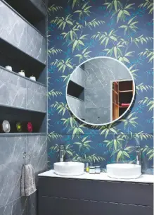  ??  ?? BATHROOM This bold new space was designed to include colourful references to the couple’s life in Asia, such as the textured leaf-print wallpaper, alongside practical inset storage.
Oriental Bamboo Midnight wallpaper, £60 a roll, Graham & Brown. HIB LED ambient round mirror, £269.95, Victorian Plumbing