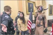  ?? ASSOCIATED PRESS FILE PHOTO ?? Supporters of President Donald Trump, including Jacob Chansley, right with fur hat, are confronted by U.S. Capitol Police officers outside the Senate Chamber inside the Capitol on Jan. 6.