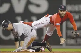  ?? The Associated Press ?? Boston Red Sox second baseman Ian Kinsler, right, forces out New York Yankees’ Brett Gardner during the seventh inning of Game 1 in their American League Division Series on Friday in Boston. The Red Sox won 5-4.