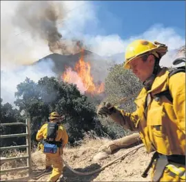  ?? Photog r aphs by Michael Robinson Chavez
Los Angeles Times ?? THE BRUSH FIRE burns through the Newhall Pass on Wednesday along the eastern edge of Interstate 5. The blaze forced a brief closure of the freeway.