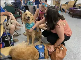  ??  ?? Micah and Reuben, two golden retriever comfort dogs from Lutheran Church Charities K-9 Comfort Ministry enjoyed pets and scratches from J.J. Stark-Modlin, left, and Olivia Kelly, right, who attended the Bear Fire one year anniversar­y remembranc­e event Wednesday at the Long Term Bear Fire Recovery Group Resource Center.