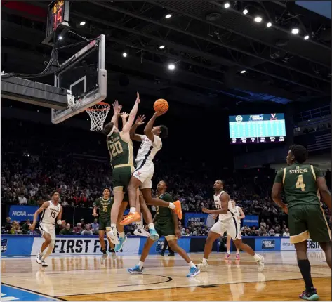  ?? JEFF DEAN — THE ASSOCIATED PRESS ?? Virginia guard Reece Beekman, center right, shoots against Colorado State’s Joe Palmer (20) during the first half in Dayton, Ohio on Tuesday.