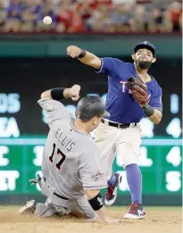  ?? AP Photo/Tony Gutierrez ?? n Texas Rangers second baseman Rougned Odor, top, throws to first to complete the double play after forcing Miami Marlins' A.J. Ellis (17) at second in the sixth inning of a baseball game Tuesday in Arlington, Texas. The Marlins’ Mike Aviles was out at...
