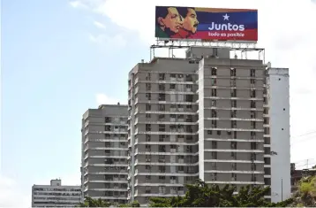  ??  ?? A billboard with electoral advertisin­g of Venezuelan President and re-election candidate Nicolas Maduro is seen atop a building, in Caracas. — AFP photo
