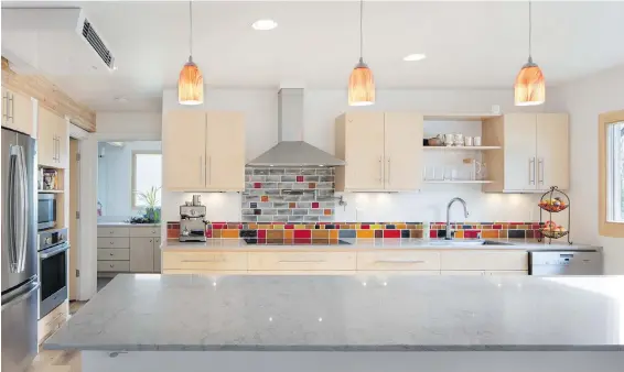  ?? STEVE RINGMAN PHOTOS, SEATTLE TIMES ?? Backsplash glass tiles in this West Seattle home are made from recycled glass, and bathroom tiles contain 66 per cent recycled material. For the kitchen countertop­s, the homeowners went with quartz because “quartz was better than quarried stone.”