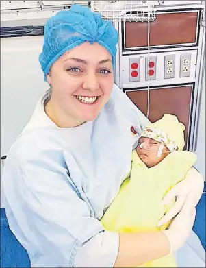  ?? PHOTO SUBMITTED/MARY MACKINNON ?? Mary MacKinnon of Westmount is shown holding an infant in Quito, Ecuador. MacKinnon was one of 24 students and four staff members to travel to the country as part of the Cape Breton University Internatio­nal Nursing Experience.