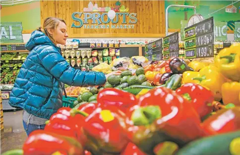  ?? GABRIELA CAMPOS/THE NEW MEXICAN ?? Briar Wren, a student from Southweste­rn College, shops Monday for produce at Sprouts at the DeVargas Center. Sprouts is one of four Santa Fe retailers that have signed on with Instacart for shopping service and delivery.