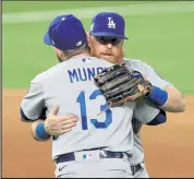  ?? Tom Pennington / Getty Images ?? The Dodgers’ Justin Turner, right, and Max Muncy celebrate after beating the Rays in Game 5 of the World Series on Sunday at Globe Life Field in Arlington, Texas.
