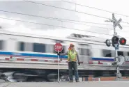  ?? AAron Ontiveroz, Denver Post file ?? ALine flagger Chris Dugent holds a stop sign as a train passes at Steele Street on June 19.