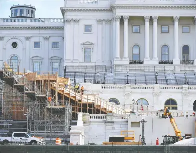  ?? MANDEL NGAN / AFP VIA GETTY IMAGES ?? Workers construct the stage for the presidenti­al inaugurati­on at the U.S. Capitol in Washington, D.C.