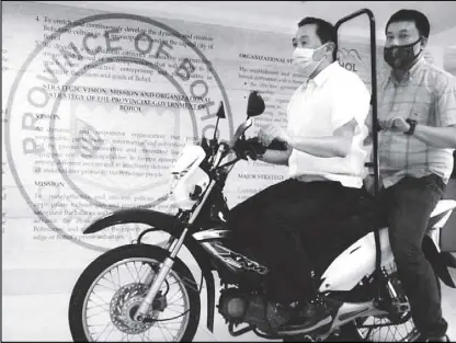  ??  ?? Bohol Gov. Arthur Yap shows a motorcycle prototype that he proposed for backriding as the country is going through a pandemic.