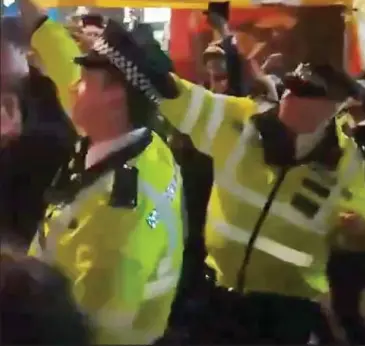  ??  ?? Beat bobbies: Officers dance with protesters at Oxford Circus on Wednesday night Sleeping policeman: An officer appears to doze in his car at Marble Arch