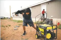  ?? JAKE BACON/ASSOCIATED PRESS ?? Jayden Long, 13, starts the generator behind his Kaibeto home May 8 on the Navajo Reservatio­n in Arizona. An ambitious project to connect hundreds of homes to the electric grid on the country’s largest Native American reservatio­n is wrapping up.