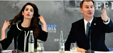  ??  ?? Special envoy: Mrs Clooney sits flicking her hair as Mr Hunt speaks in France yesterday