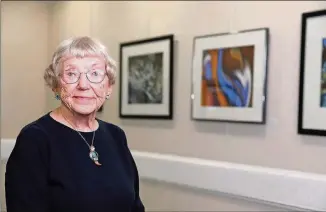  ?? JASON GETZ PHOTOS / SPECIAL TO THE AJC ?? Ruth Gogel, whose photograph­s are in permanent collection­s across Georgia, poses with her work in the gallery at Clairmont Place.