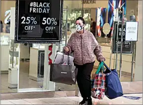  ?? RINGO H.W. CHIU / AP ?? A Black Friday shopper carries bags at the Glendale Galleria in Glendale, Calif., Friday.