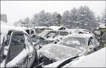  ?? STEPHEN MCCAUSLAND / ASSOCIATED PRESS ?? Emergency personnel check cars Wednesday after a series of accidents along Interstate 95 in Etna, Maine. State police said some people suffered serious injuries in the pileup, which closed parts of the highway for hours.