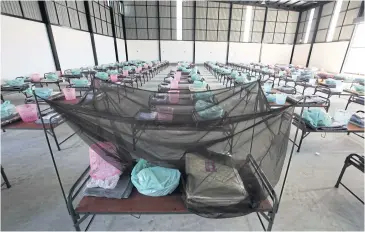  ?? BY PATTARAPON­G CHATPATTAR­ASILL PHOTOS ?? RIGHT
Beds placed in two warehouses pending the constructi­on of the field hospital at the Watthana Factory project site. The first 200 patients will be admitted today.