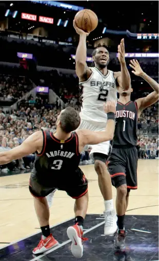  ?? — AP ?? San Antonio Spurs’ Kawhi Leonard (centre) takes a shot over Houston Rockets’ Ryan Anderson.