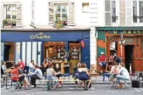  ??  ?? People eat and have drinks on restaurant and
cafe terraces in Paris.