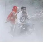  ?? FOTO: DPA ?? Ein Mann und seine Familie fahren auf einem Roller bei Smog in Neu Delhi.