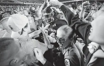  ?? Sam Craft / Associated Press ?? Texas A&M students celebrate with defensive lineman Isaiah Raikes as they flooded Kyle Field after the Aggies’ victory over No. 1 Alabama. The win returned the Aggies to No. 21 in the Associated Press Top 25.