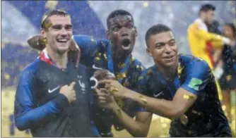  ?? THE ASSOCIATED PRESS ?? France’s Antoine Griezmann, points to two stars on his jersey indicating two world cup wins, as he celebrates with Paul Pogba and Kylian Mbappe after a 4-2 win over Croatia in the World Cup final on Sunday.