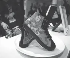  ?? CHEN JINGYI / CHINA DAILY ?? A pair of custom shoes adorned with traditiona­l Chinese elements at a booth in the 20th Jinjiang Footwear Exposition in Jinjiang, Fujian province.