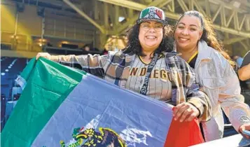  ?? ALEXANDRA MENDOZA U-T ?? Jennifer y Denise Leyva posan junto a la bandera mexicana y la gorra que les firmo el boxeador Canelo Álvarez en el Petco Park de San Diego