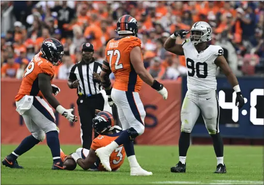  ?? ANDY CROSS — THE DENVER POST ?? Broncos center Lloyd Cushenberr­y III, left, helps quarterbac­k Russell Wilson get back on his feet after he was sacked by Raiders defensive tackle Jerry Tillery in the fourth quarter at Empower Field at Mile High on Sunday.