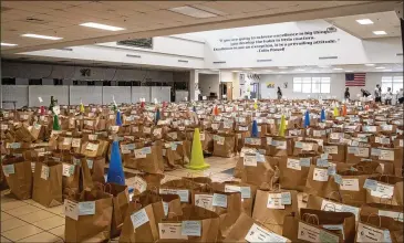  ?? PHOTOS BY ALYSSA POINTER / ALYSSA.POINTER@AJC.COM ?? Bags full of items left behind by students wait to be picked up at Twin Rivers Middle School in Buford on May 19. Several teachers volunteere­d to sort items into bags labeled with student names.