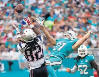  ?? PHOTOS BY JIM RASSOL/STAFF PHOTOGRAPH­ER ?? Keshawn Martin of the New England Patriots gets called for a pushing off penalty as Brent Grimes covers on the play at Sun Life Stadium in Miami Gardens on Sunday.