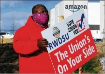  ?? AP ?? Michael Foster of the Retail, Wholesale and Department Store Union holds a sign outside an Amazon facility in Bessemer, Alabama, where labor was trying to organize workers. The movement failed.